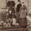 View of group of four ladies with two dogs probably at St Fort House.
