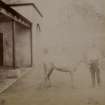 View of man with pony outside stables at St Fort House.