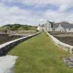 View of Rodel Hotel, Harris, looking along south wall of harbour, from south-east.