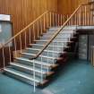 Interior. View of principal staircase, with typical wall panelling and orientation signs, NW range.