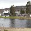 General view from the north bank of the River Tay, looking south east to the rear of Kenmore village,  showing (from left) the reading rooms (with hotel stables to fore), the Kenmore Hotel, the boathouse and boathouse cottage.