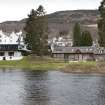 General view from the north bank of the River Tay, looking south east to the rear of Kenmore village,  showing (from left) the Kenmore Hotel, the boathouse and boathouse cottage.