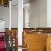 View looking along side aisle , showing pews and supporting columns of side gallery.