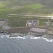 Oblique aerial view of Dounreay Nuclear Development Establishment, centred on the site of the storehouses, looking SE.