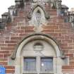 Detail of vented opening and round arched window head to south pavilion gable.