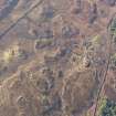 Oblique aerial view of the buildings and field boundaries, looking SW.