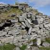 The broch wall at the SSW. Their is subsidence in the main broch wall, and the collapsing guard cell roof is visible at left. The internal gallery wall face in the upper part of the photograph has probably been remodelled and the small opening is likely to be a later feature.