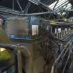 Interior. Boiler house. Conveyor which delivers coal to boiler hoppers. The conveyer is lengthened or shortened by the 'iron horse' on which the operator is sitting, to the left of the image.