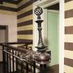 Interior. Detail of wolf-dragon bannister end and wrought iron finial to stair hall balustrade.