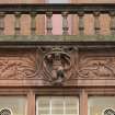 Exterior. Detail of carved architrave above the window of the west elevation..