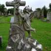 Image showing a statue of an angel placing a garland of flowers on a cross. The Grange Cemetery, Edinburgh.