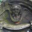 Detail of relief showing the head and wings of an angel, weathered. Saint Cuthbert's Cemetery, Edinburgh.