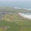 General oblique aerial view of Cruden bay centred on Cruden Bay Golf Courses, looking to the NE.