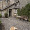 General view of main courtyard entrance and porch with dog.