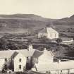 View of Colonsay and Oronsay Parish Church, in the foreground is the current Colonsay Hotel, at Scalasaig, Colonsay.
Titled: '102. Colonsay church and back of Inn.'
PHOTOGRAPH ALBUM NO 186: J B MACKENZIE ALBUMS vol.1