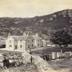 View of Colonsay Hotel, formerly Inn, with a group of children in foreground at Scalasaig, Colonsay.
Titled:  '105. Colonsay Inn'.
PHOTOGRAPH ALBUM NO 186: J B MACKENZIE ALBUM