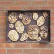 Detail of clay faces displayed on the exterior of the music block.