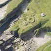 Oblique aerial view of Nybster Broch and Nybster Commemorative Monument, looking SSW.