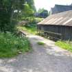 Exterior view showing a small wooden bridge, from a Standing Building Survey, Glamis Mill, Glamis, Angus.