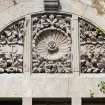 Detail of carved tympanum above first floor window on south elevation.