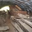 Interior, west storage shed. General view of uncut stone and ammunition box storage area from south. These ammunition boxes were halved and used to transport the fragile cut and polished hones.