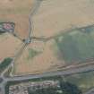 Oblique aerial view of the cropmarks of the enclosure with Easter Broomhouse farmstead beyond, looking SSW.