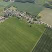 Oblique aerial view of Athelstaneford village with the cropmarks of possible buildings and road adjacent, looking SSE.