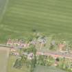 Oblique aerial view of Athelstaneford village with the cropmarks of possible buildings and road adjacent, looking N.