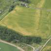 Oblique aerial view of a cropmarks of the enclosure, looking SW.