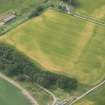 Oblique aerial view of a cropmarks of the enclosure, looking SW.