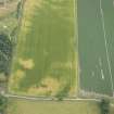 Oblique aerial view of the cropmarks of the enclosure, possible sunken floored building and pits, looking SE.