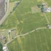 Oblique aerial view of the cropmarks of the ring ditch, track and pits, looking W.
