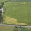 Oblique aerial view of the cropmarks of the possible souterain, round house and pits, looking SE.