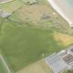 Oblique aerial view of the cropmarks of the ring ditch and the remains of the windmill at Sandend, looking NW.