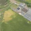 Oblique aerial view of the remains of the windmill and Glenglassaugh Distillery at Sandend, looking ENE.