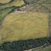 Oblique aerial view centred on the cropmarks of the unenclosed settlement, barrows, timber halls, linear features and pits, looking NE.