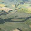 General oblique aerial view centred on the cropmarks of the unenclosed settlement, ring ditches, pits and rig with Stracathro Roman Fort and Temporary Camp adjacent at Smiddyhill, looking to the SSW.