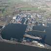 Oblique aerial view of HM Dockyard Rosyth centred on the Main Basin with the Goliath Crane beyond, looking NNE.