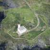 Oblique aerial view of Fidra lighthouse and cottage block, and metal wire running down cliff face, looking ESE.