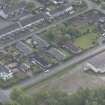 Oblique aerial view of five long rectangular single story timber houses, looking SE.