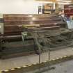 Interior. New weaving shed. View of warping or beaming machine. This takes single yarn strands from many bobbins on the frame and winds under tension onto a beam ready for weaving. The short beam is visible.