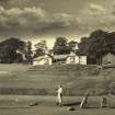 First tee of the Merchants of Edinburgh golf course being played by Alice Clark and Olive Gardener in a medal finals competition, the club house and original pro shop in the background.
