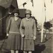 Lady golfers M Coults and M Belford with partial view of the Merchants of Edinburgh Golf Clubhouse.