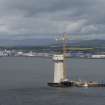 Forth crossing under construction. View of support pillar with crane and barge from road bridge to east