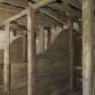 Interior. Stable, view of timber built stalls with feeding trough visible (right)