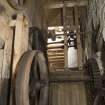 Interior. Ground floor. Threshing barn, detail of threshing machine drive shaft and belt drive wheels in gear cupboard
