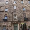 Detail of the entrances, first, second and third floor windows at Working Men's Home, 70-76 Grove Street, Edinburgh.