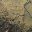 Oblique aerial view of the mining remains and field systems, looking NE.