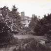 View of St Germains House visible behind trees from garden.