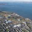 General oblique aerial view of the Granton area of Edinburgh centred on the Gasworks, West Shore Road and the proposed site for the RCAHMS store with Cramond Island in the background, looking WNW.